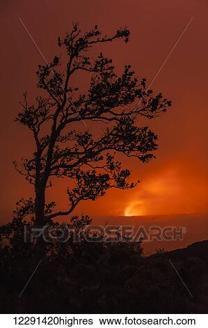 Stock Photograph - The glow of Pele shines through clouds at night at the Kilauea Caldera and Halemaumau Crater in Hawaii Volcanoes National Park; Island of Hawaii, Hawaii, United States of America. Fotosearch