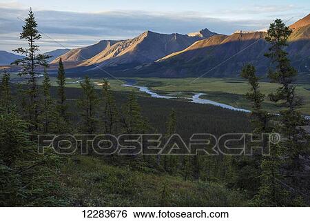 The last rays of sunlight hit the tops of the mountains along the Wind River in the Peel watershed; Yukon, Canada View Large Photo Image Stock Photograph - The last rays of sunlight hit the tops of the mountains along the Wind River in the Peel watershed; Yukon, Canada. Fotosearch