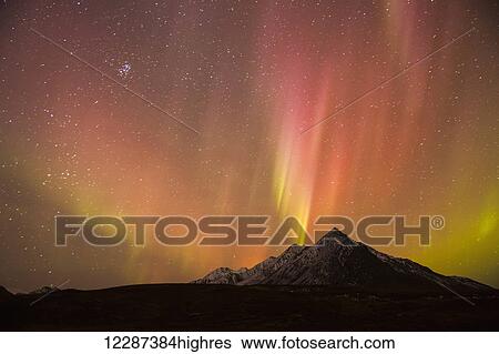 Stock Photograph - The Northern lights (aurora borealis) over top of Angelcomb Peak, Dempster Highway; Yukon, Canada. Fotosearch