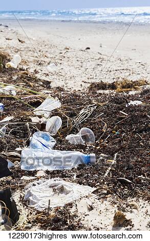 Stock Photograph - The plastic pollution and debris along the beach in the Carribbean, a byproduct of resorts and tourism having an environmental impact on the pristine beaches; Varadero, Cuba. Fotosearch