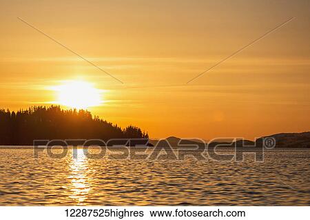 The setting sun silhouettes the forest ridges and peninsulas in Prince William Sound; Whittier, Alaska, United States of America View Large Photo Image Stock Photograph - The setting sun silhouettes the forest ridges and peninsulas in Prince William Sound; Whittier, Alaska, United States of America. Fotosearch