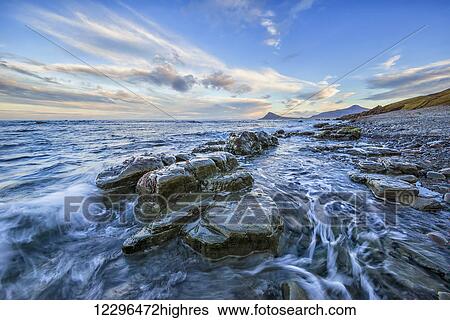 The waves crash into the shoreline; West Fjords, Iceland View Large Photo Image Stock Photograph - The waves crash into the shoreline; West Fjords, Iceland. Fotosearch