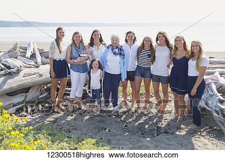 Stock Photograph - Three generations of women in a family posing on a beach, a grandmother and eight granddaughters; Fox Spit, Whidbey Island, Washington, United States of America. Fotosearch