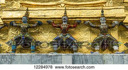 Three statues along a gold wall, Temple of the Emerald Buddha (Wat Phra Kaew); Bangkok, Thailand View Large Photo Image Stock Photo - Three statues along a gold wall, Temple of the Emerald Buddha (Wat Phra Kaew); Bangkok, Thailand. Fotosearch