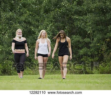 Stock Image - Three young gymnasts walking in a park after practicing their routine; Edmonton, Alberta, Canada. Fotosearch