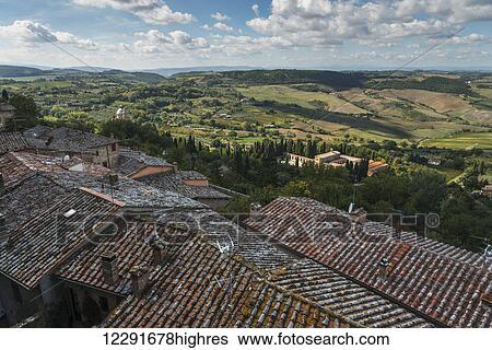 Stock Photograph - Tile rooftops and a view of the landscape; Montepulciano, Umbria, Italy. Fotosearch