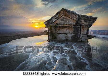 Stock Photograph - Tomb submerged in a travertine pool in Hierapolis at sunset; Pamukkale, Turkey. Fotosearch