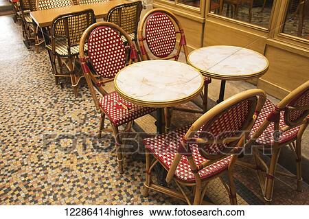 Stock Photograph - Traditional bistro tables and chairs on a sidewalk; Paris, France. Fotosearch