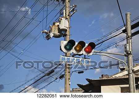 Stock Image - Traffic light with street sign and transmission lines; Kyoto, Japan. Fotosearch
