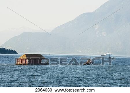 Tug Boat Pulling Logs Through The Ocean With Mountains In The Background, Howe Sound, Bc View Large Photo Image Stock Image - Tug Boat Pulling Logs Through The Ocean With Mountains In The Background, Howe Sound, Bc. Fotosearch