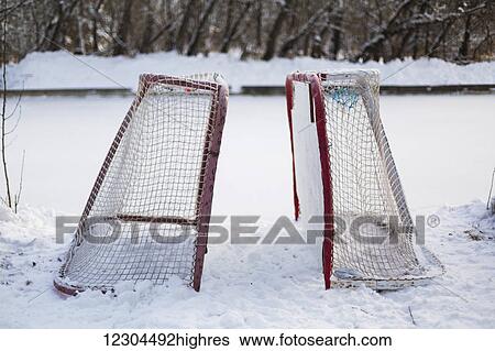 Stock Photograph - Two hockey nets in the snow beside a frozen outdoor rink; Wetaskiwin, Alberta, Canada. Fotosearch