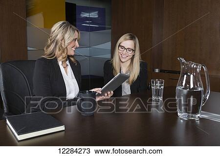 Two professional business women during a training session in a boardroom; St. Albert, Alberta, Canada View Large Photo Image Stock Image - Two professional business women during a training session in a boardroom; St. Albert, Alberta, Canada. Fotosearch
