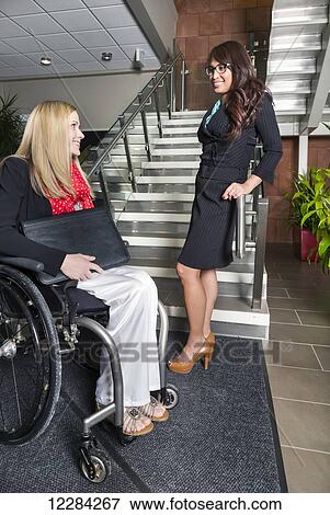 Two professional business women in the lobby of an office, one of which is a paraplegic in a wheelchair; St. Albert, Alberta, Canada View Large Photo Image Stock Photo - Two professional business women in the lobby of an office, one of which is a paraplegic in a wheelchair; St. Albert, Alberta, Canada. Fotosearch