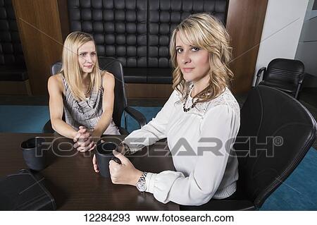 Stock Image - Two professional business women meeting in a boardroom; St. Albert, Alberta, Canada. Fotosearch