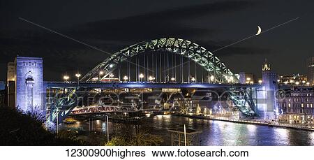Tyne Bridge illuminated at nighttime over River Tyne with a crescent moon in the sky; Newcastle, Tyne and Wear, England View Large Photo Image Stock Photograph - Tyne Bridge illuminated at nighttime over River Tyne with a crescent moon in the sky; Newcastle, Tyne and Wear, England. Fotosearch