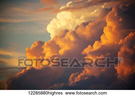 Stock Photograph - Unusual cloud formations glowing at sunset; Maui, Hawaii, United States of America. Fotosearch