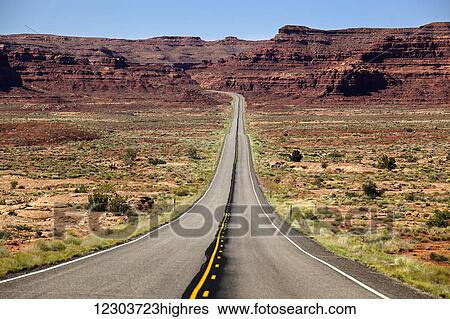 Utah highway stretching into the distance with rock cliffs and blue skies in the background and desert vegetation on either side of the road; Utah, United States of America View Large Photo Image Stock Photograph - Utah highway stretching into the distance with rock cliffs and blue skies in the background and desert vegetation on either side of the road; Utah, United States of America. Fotosearch