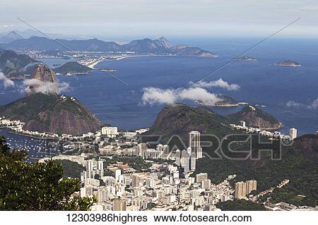 Stock Photograph - View of Rio and Sugarloaf Mountain from Christ the Redeemer statue, Corcovado mountain, Tijaca National Park; Rio de Janeiro, Brazil. Fotosearch