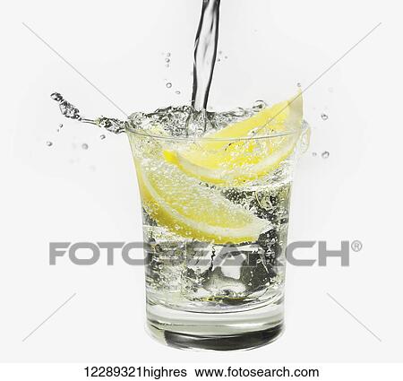 Water pouring into a glass with lemon wedges against a white background; Toronto, Ontario, Canada View Large Photo Image Stock Photograph - Water pouring into a glass with lemon wedges against a white background; Toronto, Ontario, Canada. Fotosearch