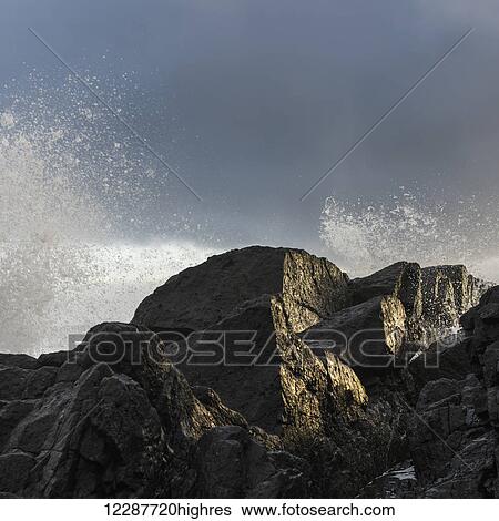 Stock Photograph - Water splashing in the air from waves crashing against the rocks; Tofino, British Columbia, Canada. Fotosearch