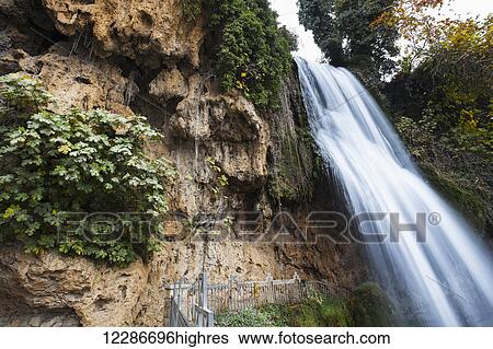 Stock Photograph - Waterfall over a rugged cliff with foliage; Edessa, Greece. Fotosearch