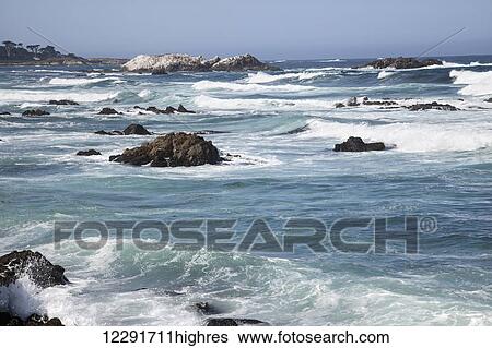 Stock Photograph - Waves breaking near shore on the rocks along the California coast; Monterey, California, United States of America. Fotosearch