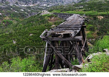 Stock Photograph - White Pass Railroad original trestle bridge over the river; Skagway, Alaska, United States of America. Fotosearch