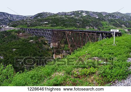 Stock Photograph - White Pass Railroad original trestle bridge over the river; Skagway, Alaska, United States of America. Fotosearch
