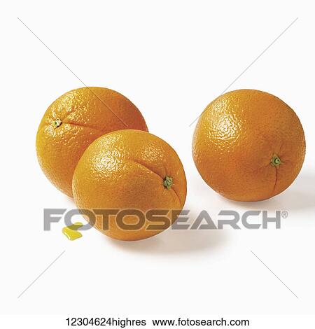 Stock Photograph - Whole oranges and a drop of juice on a white background; Toronto, Ontario, Canada. Fotosearch