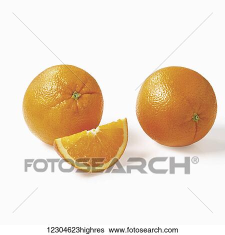 Stock Photograph - Whole oranges and a wedge on a white background; Toronto, Ontario, Canada. Fotosearch