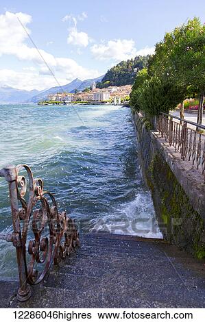 Wind sends Lake Como water splashing against a waterfront staircase and sidewalk; Bellagio, Italy View Large Photo Image Stock Photograph - Wind sends Lake Como water splashing against a waterfront staircase and sidewalk; Bellagio, Italy. Fotosearch