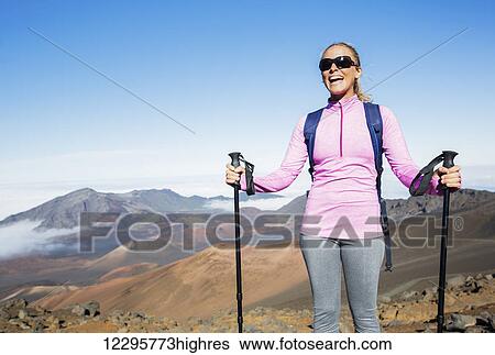 Stock Photograph - Woman hiking on beautiful mountain trail. Trekking and backpacking in the mountains. Healthy lifestyle outdoor adventure concept.. Fotosearch