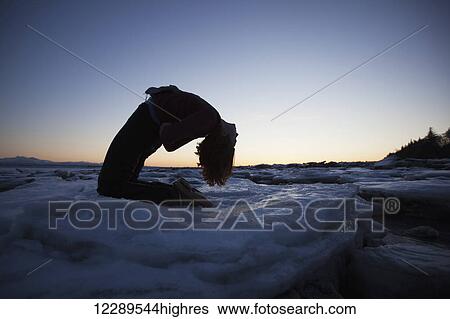 Woman practices yoga on an ice chunk on a beach in Homer, Southcentral Alaska View Large Photo Image Stock Photograph - Woman practices yoga on an ice chunk on a beach in Homer, Southcentral Alaska. Fotosearch