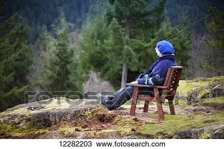 Woman sitting in a chair looking at nature; Bowen Island, British Columbia, Canada View Large Photo Image Stock Image - Woman sitting in a chair looking at nature; Bowen Island, British Columbia, Canada. Fotosearch