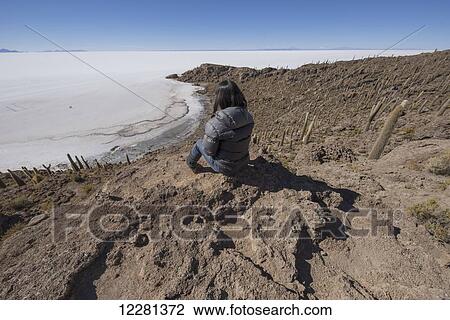 Woman sitting on an island of rock and cactus called Incahuasi; Uyuni, Bolivia View Large Photo Image Stock Image - Woman sitting on an island of rock and cactus called Incahuasi; Uyuni, Bolivia. Fotosearch