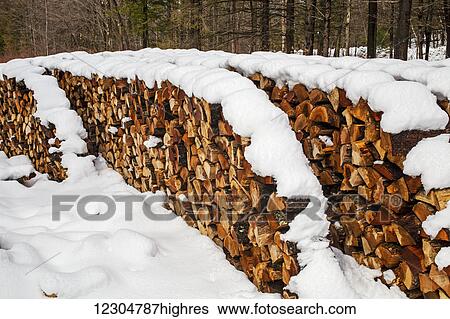 Stock Photograph - Wood pile in the snow; Waterloo, Quebec, Canada. Fotosearch