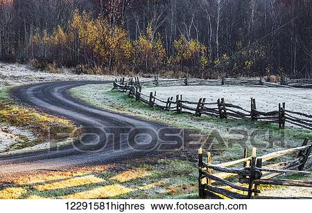 Wooden rail fence in a frost covered grass field with trees in autumn colours and a winding road; Iron Hill, Quebec, Canada View Large Photo Image Stock Photograph - Wooden rail fence in a frost covered grass field with trees in autumn colours and a winding road; Iron Hill, Quebec, Canada. Fotosearch