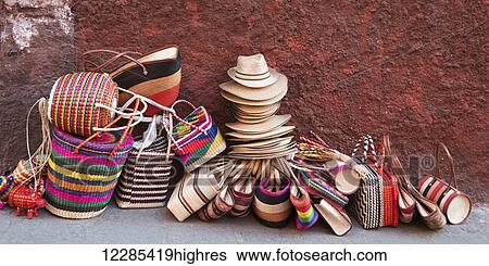 Woven souvenirs on display on a sidewalk against a wall; San Miguel de Allende, Guanajuato, Mexico View Large Photo Image Stock Photograph - Woven souvenirs on display on a sidewalk against a wall; San Miguel de Allende, Guanajuato, Mexico. Fotosearch