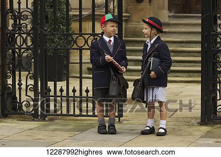 Young boy and girl students in uniform talking outside the school; London, England View Large Photo Image Stock Photograph - Young boy and girl students in uniform talking outside the school; London, England. Fotosearch