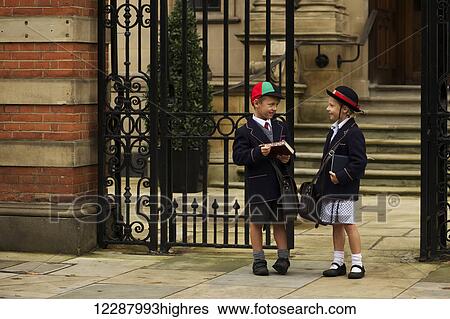 Young boy and girl students in uniform talking outside the school; London, England View Large Photo Image Stock Photograph - Young boy and girl students in uniform talking outside the school; London, England. Fotosearch