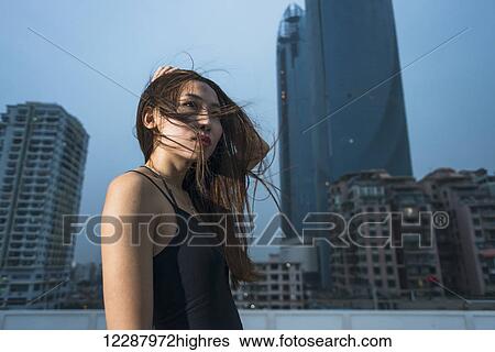 Young female model on a rooftop in evening, fresh and fashion feeling; Xiamen, Fujian, China View Large Photo Image Stock Photograph - Young female model on a rooftop in evening, fresh and fashion feeling; Xiamen, Fujian, China. Fotosearch