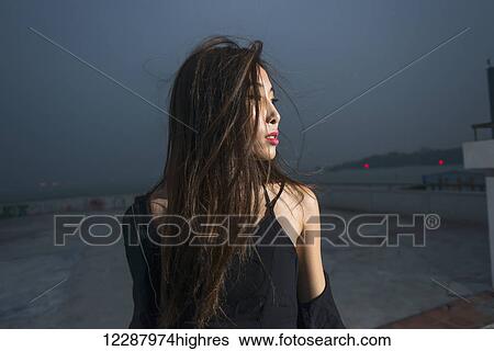 Young female model on a rooftop in evening, fresh and fashion feeling; Xiamen, Fujian, China View Large Photo Image Stock Photograph - Young female model on a rooftop in evening, fresh and fashion feeling; Xiamen, Fujian, China. Fotosearch