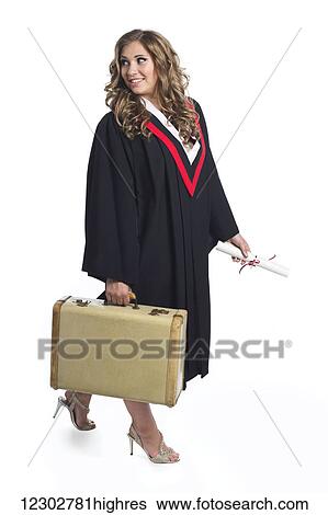 Stock Photograph - Young graduating woman holding luggage symbolizing that she is now leaving home; Edmonton, Alberta, Canada. Fotosearch