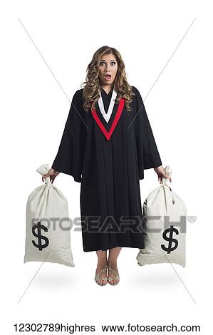 Stock Photograph - Young graduating woman holding money bags to symbolize the costs of her education; Edmonton, Alberta, Canada. Fotosearch