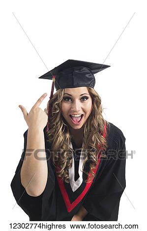 Stock Photograph - Young graduating woman pointing at her grad cap in celebration; Edmonton, Alberta, Canada. Fotosearch
