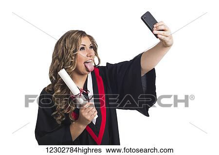 Young graduating woman taking a self-portrait with her smart phone and celebrating her graduation; Edmonton, Alberta, Canada View Large Photo Image Stock Photograph - Young graduating woman taking a self-portrait with her smart phone and celebrating her graduation; Edmonton, Alberta, Canada. Fotosearch