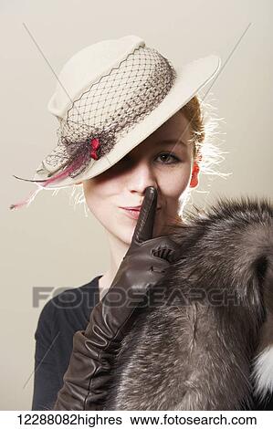 Young woman with red hair in a hat, fur coat and leather gloves with her finger on lips; Caldecott, England View Large Photo Image Stock Photograph - Young woman with red hair in a hat, fur coat and leather gloves with her finger on lips; Caldecott, England. Fotosearch
