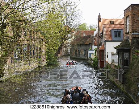 Stock Photograph - A boat tour of the canals; Bruges, Belgium. Fotosearch
