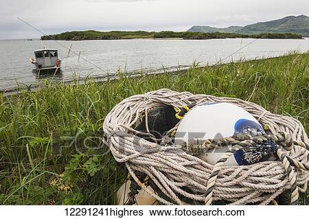 Stock Photograph - A boat waits off shore with a rope and buoy in the foreground, Kukak Bay, Katmai National Park & Preserve, Alaska.. Fotosearch