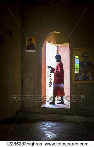 A boy walking through an illuminated doorway from an Orthodox church; Gulu, Uganda View Large Photo Image Stock Photograph - A boy walking through an illuminated doorway from an Orthodox church; Gulu, Uganda. Fotosearch
